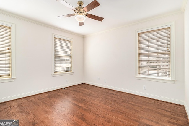 spare room featuring dark wood finished floors, ornamental molding, baseboards, and ceiling fan