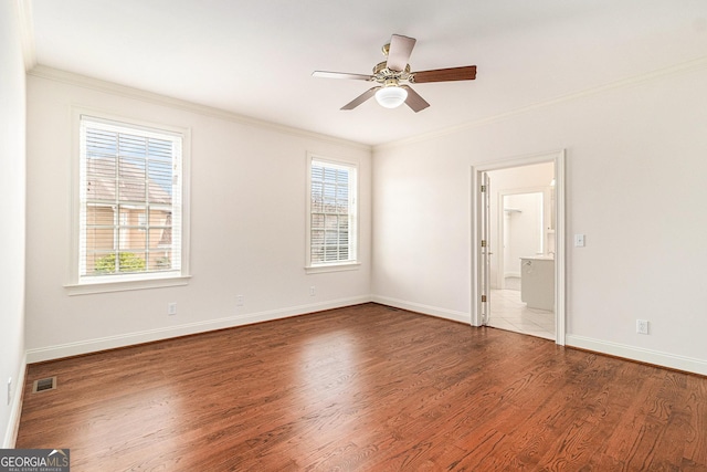 unfurnished bedroom with wood finished floors, baseboards, visible vents, ensuite bath, and ornamental molding