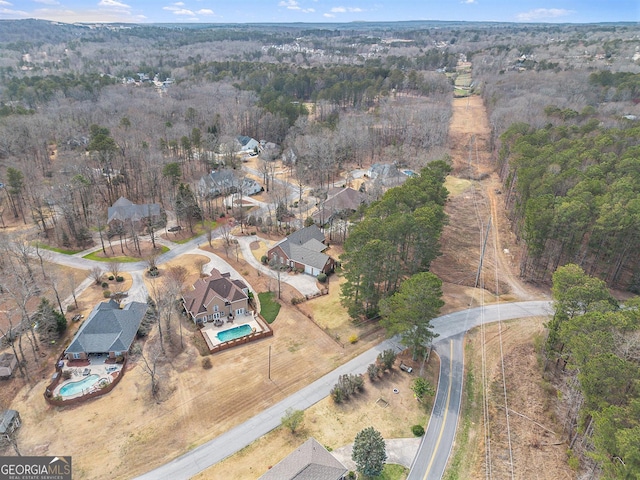 bird's eye view with a wooded view