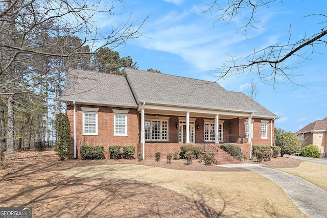 view of front of home featuring brick siding and covered porch