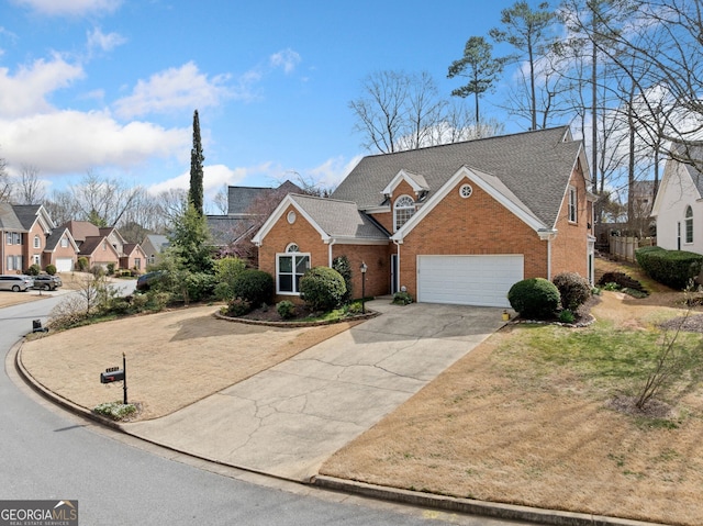 traditional-style house featuring driveway, brick siding, a shingled roof, a garage, and a residential view