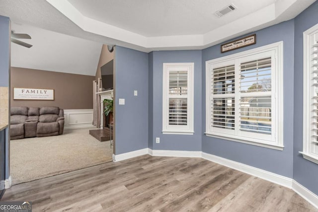 entryway with ceiling fan, baseboards, a tray ceiling, and wood finished floors