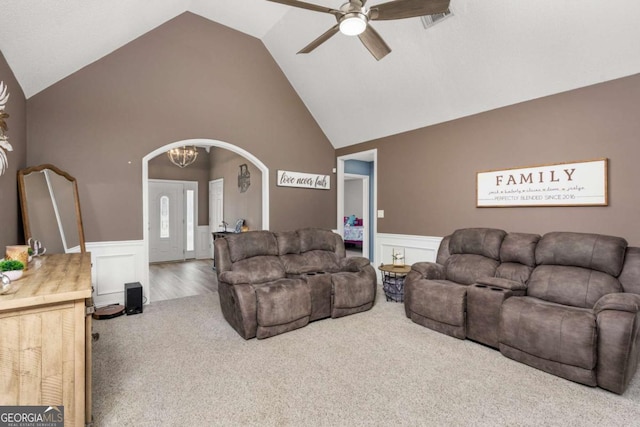 living area featuring a wainscoted wall, arched walkways, carpet floors, and ceiling fan