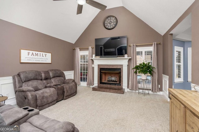 living room featuring a wealth of natural light, a brick fireplace, ceiling fan, and wainscoting