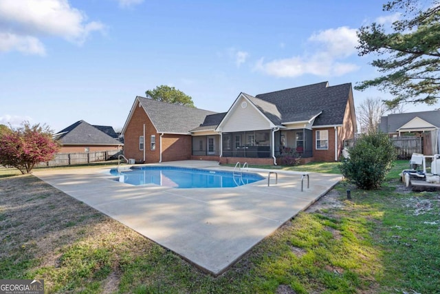 view of pool featuring a fenced in pool, fence, a yard, a sunroom, and a patio area