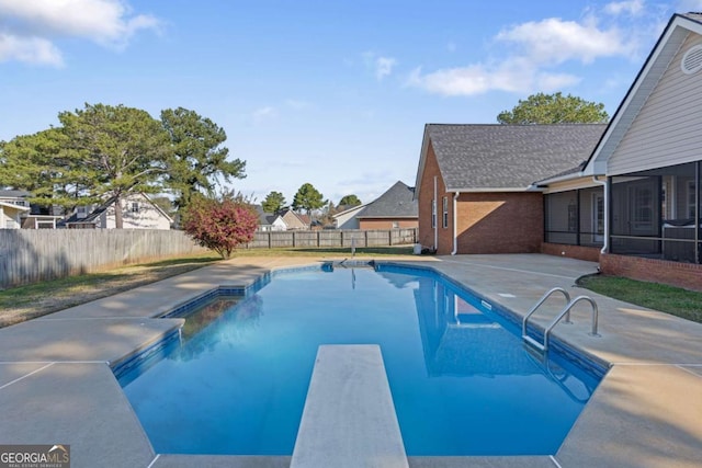 view of pool with a patio, a fenced backyard, a sunroom, a diving board, and a fenced in pool