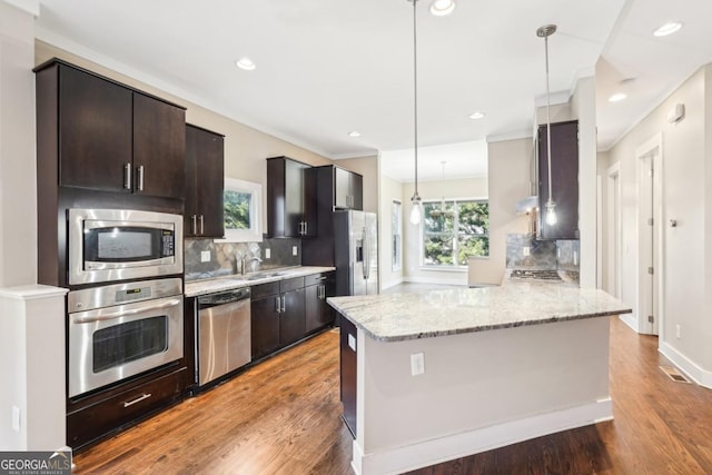 1199 Huff Rd Unit 121, Atlanta, GA 30318 - kitchen featuring stainless steel appliances, decorative backsplash, dark brown cabinets, light stone countertops, and wood finished floors