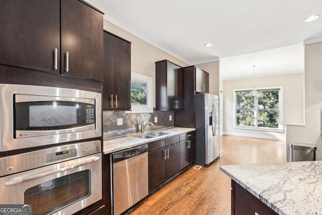 1199 Huff Rd Unit 121, Atlanta, GA 30318 - kitchen with stainless steel appliances, light wood-style flooring, dark brown cabinetry, light stone counters, and backsplash