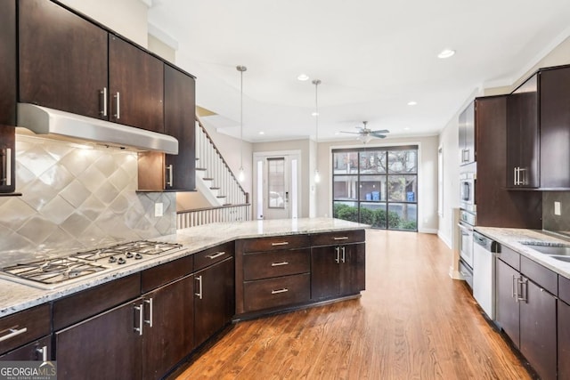 1199 Huff Rd Unit 121, Atlanta, GA 30318 - kitchen featuring under cabinet range hood, stainless steel appliances, wood finished floors, a peninsula, and backsplash