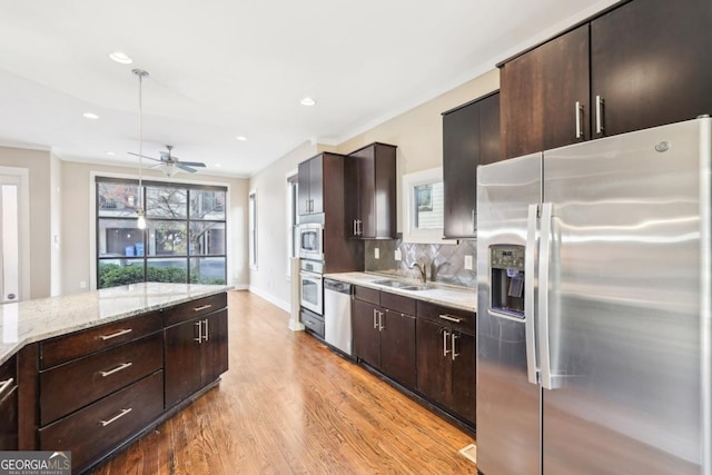 1199 Huff Rd Unit 121, Atlanta, GA 30318 - kitchen with appliances with stainless steel finishes, light wood finished floors, tasteful backsplash, dark brown cabinetry, and a ceiling fan