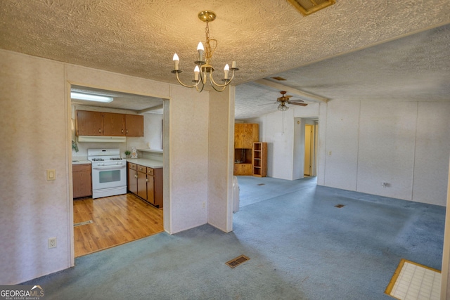 kitchen featuring under cabinet range hood, light colored carpet, light countertops, white range with gas cooktop, and brown cabinets