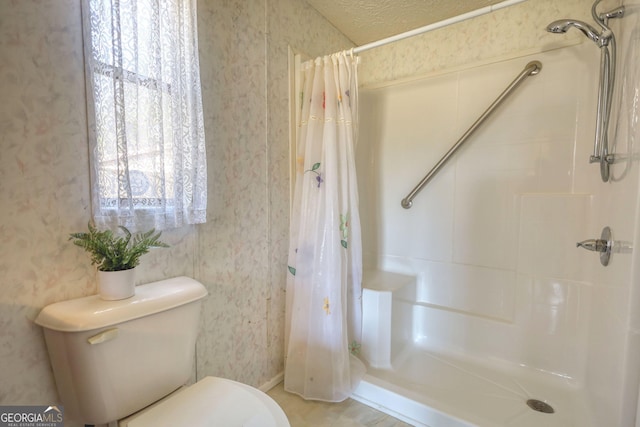 bathroom featuring toilet, a stall shower, and wallpapered walls