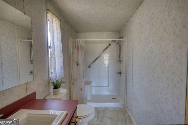 bathroom with curtained shower, toilet, vanity, and a textured ceiling