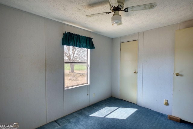 unfurnished bedroom with a textured ceiling, ceiling fan, and carpet flooring