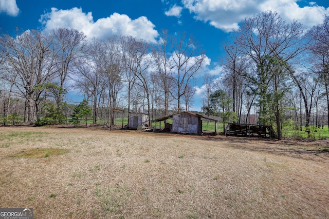 view of yard featuring an outdoor structure, a carport, and a barn