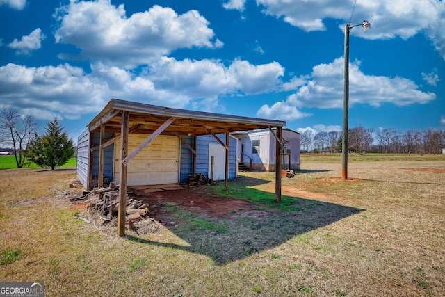 view of outbuilding featuring an outdoor structure, a carport, and driveway