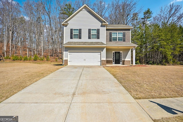 view of front facade featuring brick siding, an attached garage, concrete driveway, and a front yard