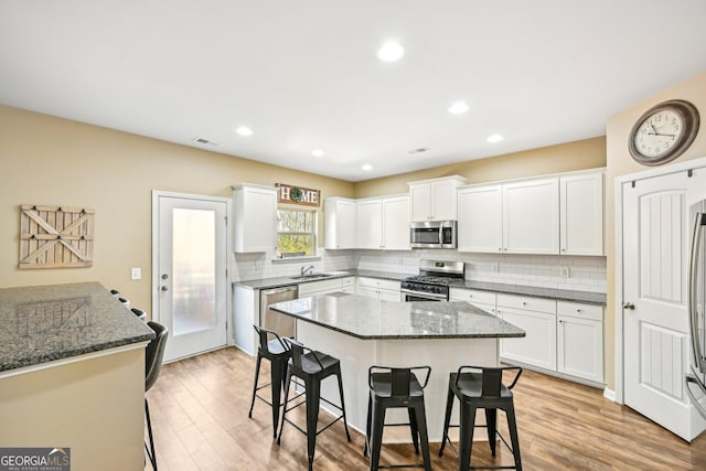 kitchen featuring a breakfast bar area, visible vents, a kitchen island, stainless steel appliances, and light wood-type flooring