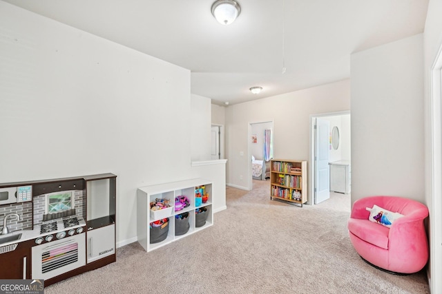 recreation room with baseboards and carpet