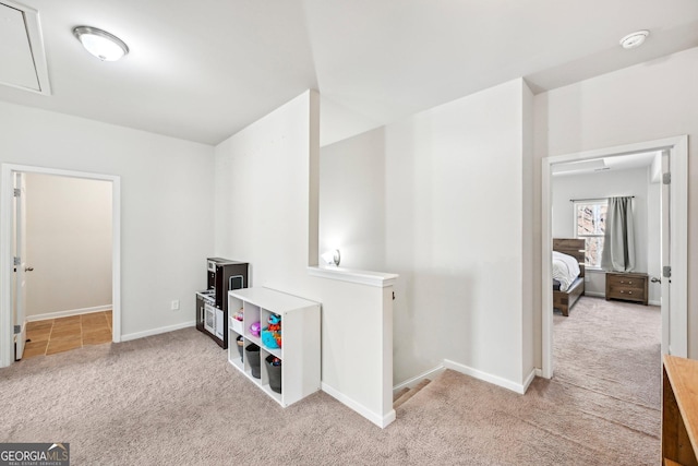 interior space featuring attic access, baseboards, and carpet floors