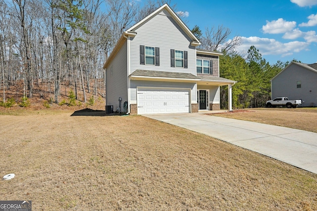 traditional home featuring an attached garage, concrete driveway, and a front lawn