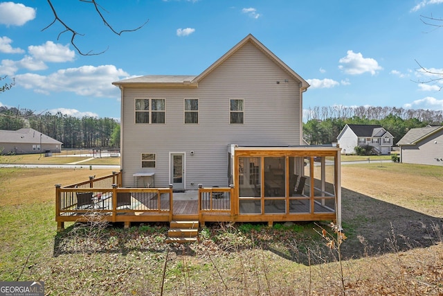 rear view of property with a wooden deck, a yard, and a sunroom