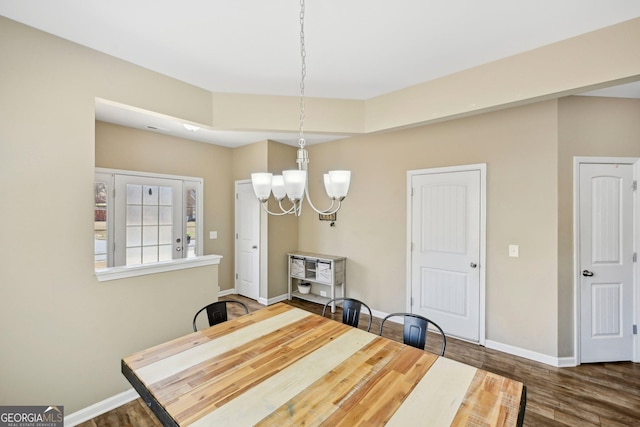 dining room with wood finished floors, baseboards, and a chandelier