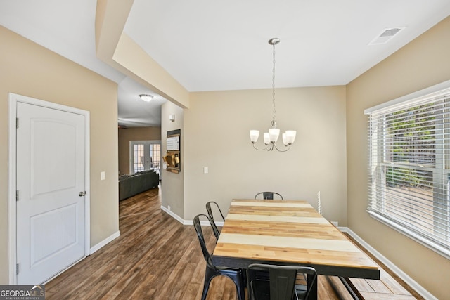 dining space featuring an inviting chandelier, dark wood-style floors, visible vents, and baseboards