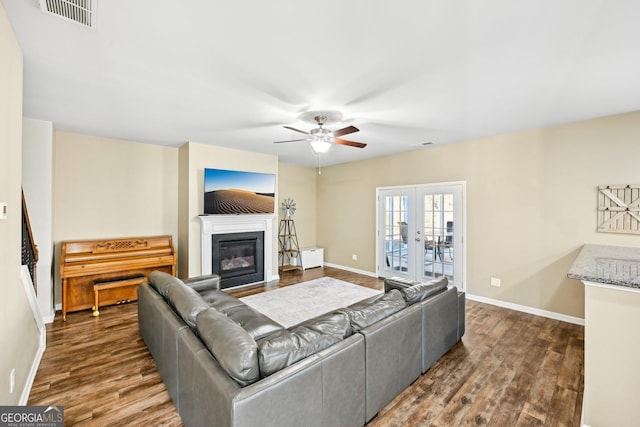 living room with visible vents, baseboards, wood finished floors, and a ceiling fan