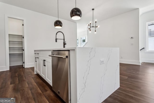 kitchen featuring a sink, dark wood-type flooring, hanging light fixtures, white cabinetry, and a kitchen island with sink