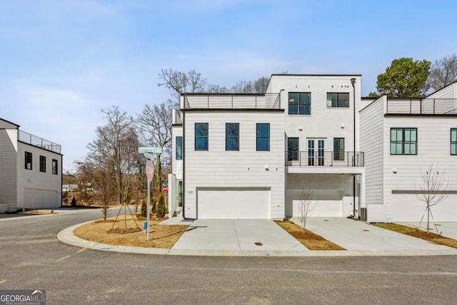 townhome / multi-family property featuring a garage, a balcony, and driveway