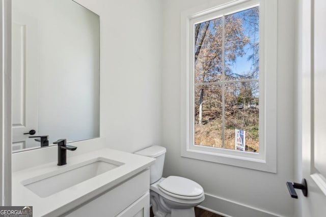 bathroom with vanity, toilet, and baseboards