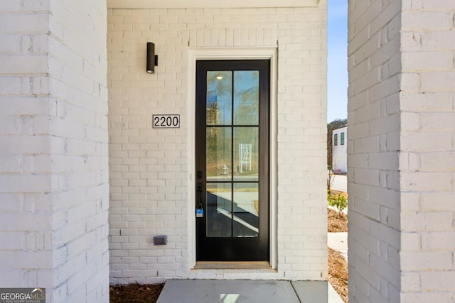 doorway to property with brick siding