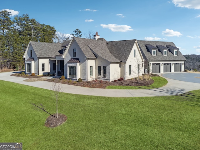 view of front of house with concrete driveway, a front yard, a shingled roof, a garage, and a chimney