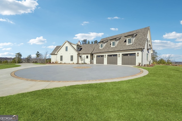 view of front of home featuring a front lawn, a chimney, roof with shingles, and curved driveway