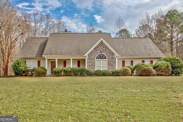 view of front facade with a front lawn, a chimney, and a shingled roof