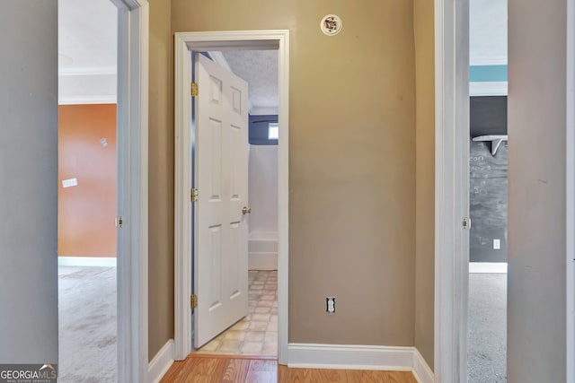 corridor featuring wood finished floors and baseboards