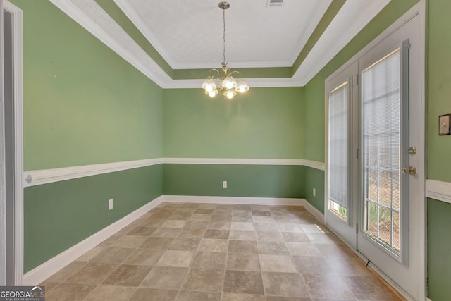 empty room featuring a tray ceiling, baseboards, a notable chandelier, and visible vents