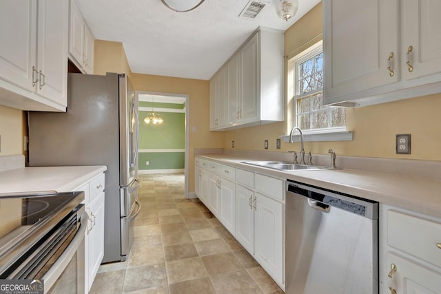 kitchen featuring a sink, stainless steel appliances, visible vents, and light countertops