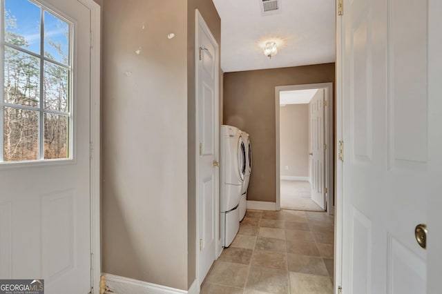 laundry room featuring visible vents, washing machine and dryer, plenty of natural light, and baseboards