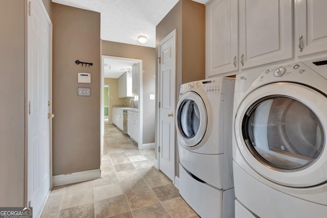 laundry room featuring baseboards, cabinet space, and washing machine and clothes dryer