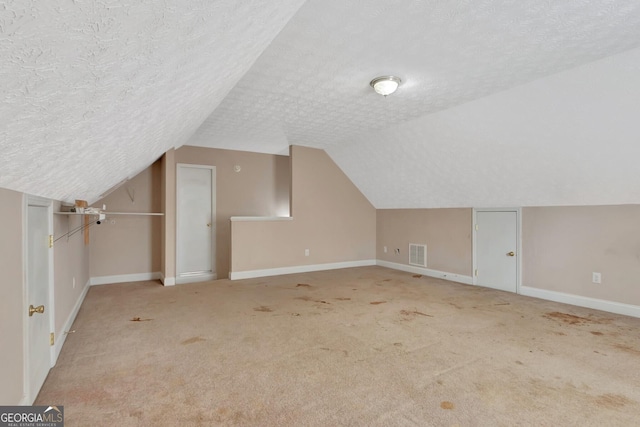 bonus room with visible vents, baseboards, and a textured ceiling