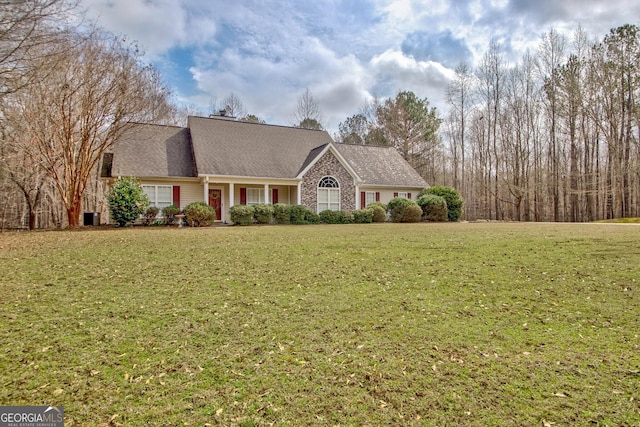 view of front of house with a front yard and roof with shingles