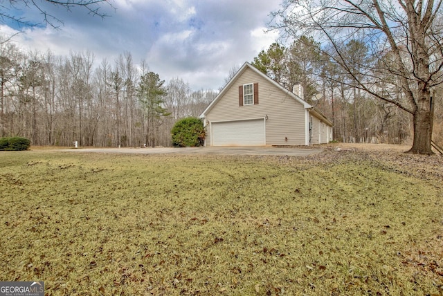 view of side of property featuring a garage, a lawn, and concrete driveway