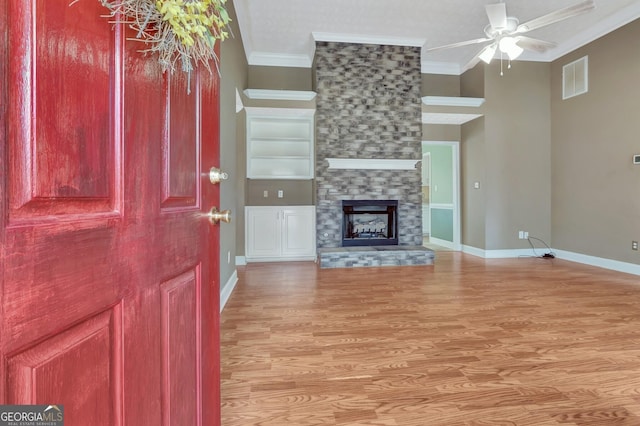 unfurnished living room featuring visible vents, light wood-style flooring, crown molding, baseboards, and ceiling fan