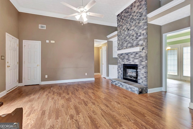 unfurnished living room with crown molding, light wood-type flooring, visible vents, and ceiling fan