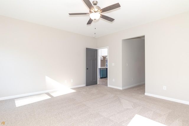 empty room with baseboards, light colored carpet, and a ceiling fan