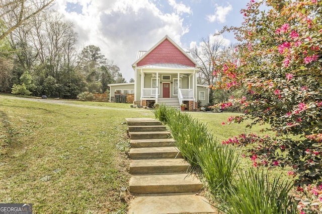 victorian home featuring a standing seam roof, a front lawn, covered porch, and metal roof