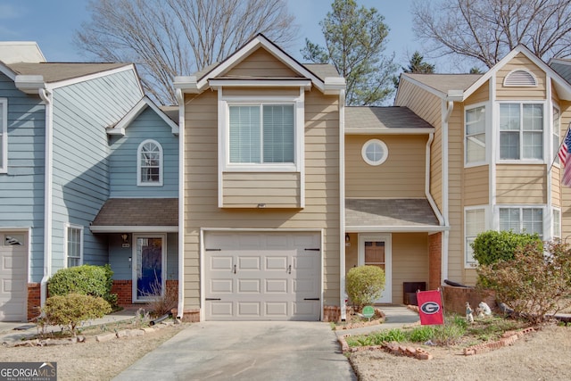 view of front facade featuring a garage, driveway, and a shingled roof