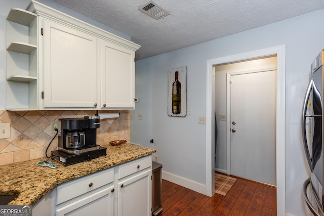 kitchen with visible vents, dark wood-type flooring, open shelves, white cabinets, and baseboards